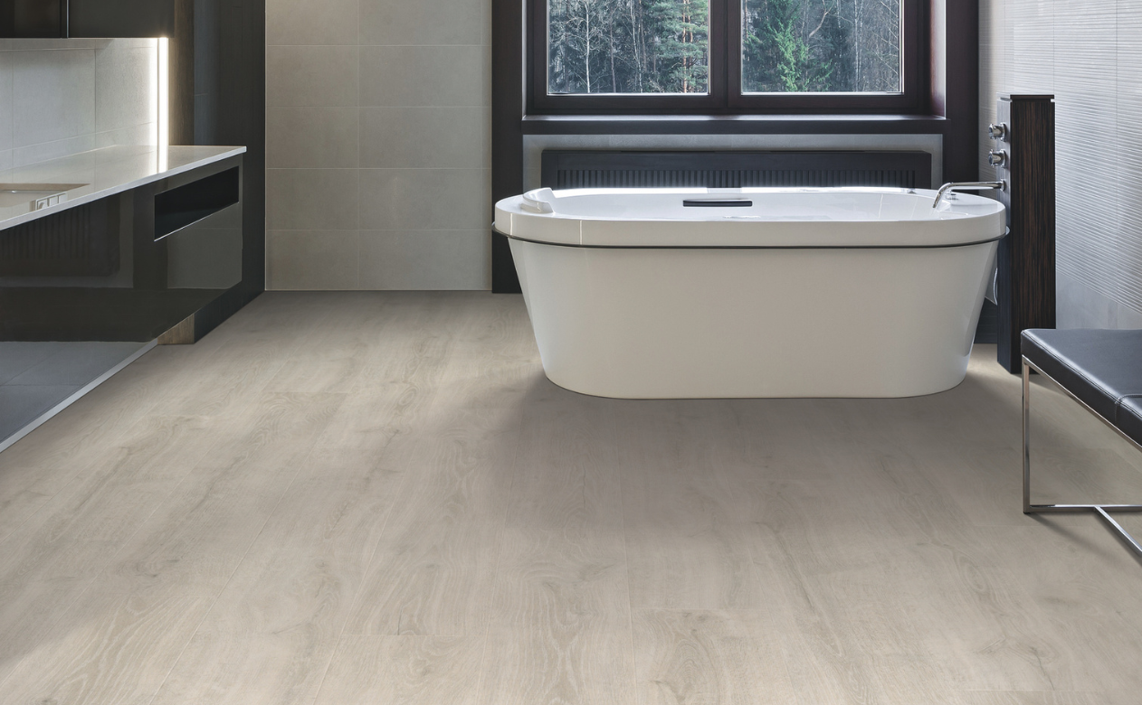 Bathroom with light, wood-look laminate floors and a bathtub